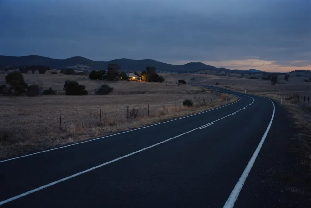 A newly sealed road crossing farmland.